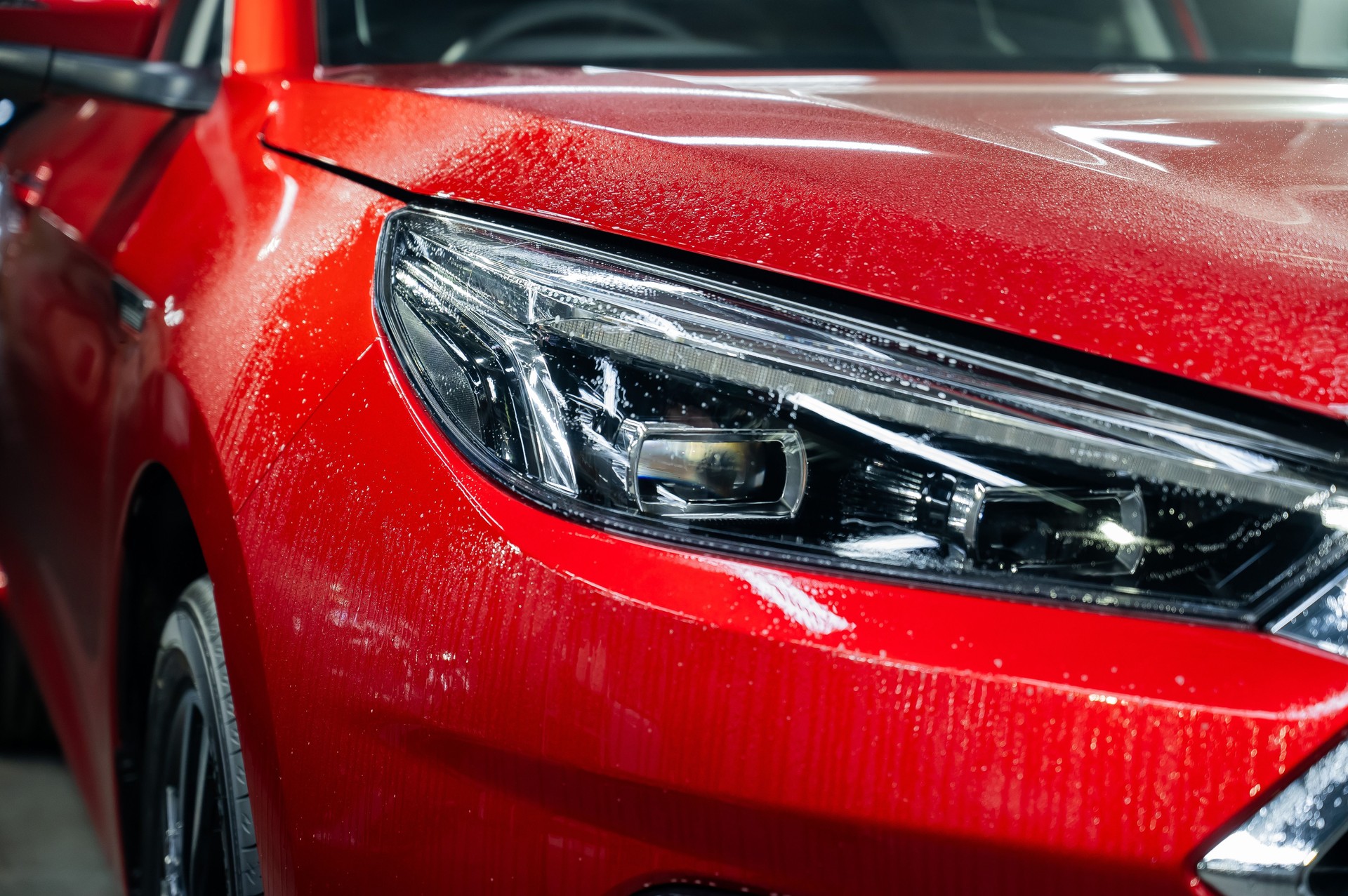 Close-up of a red car headlight with vinyl wrap.